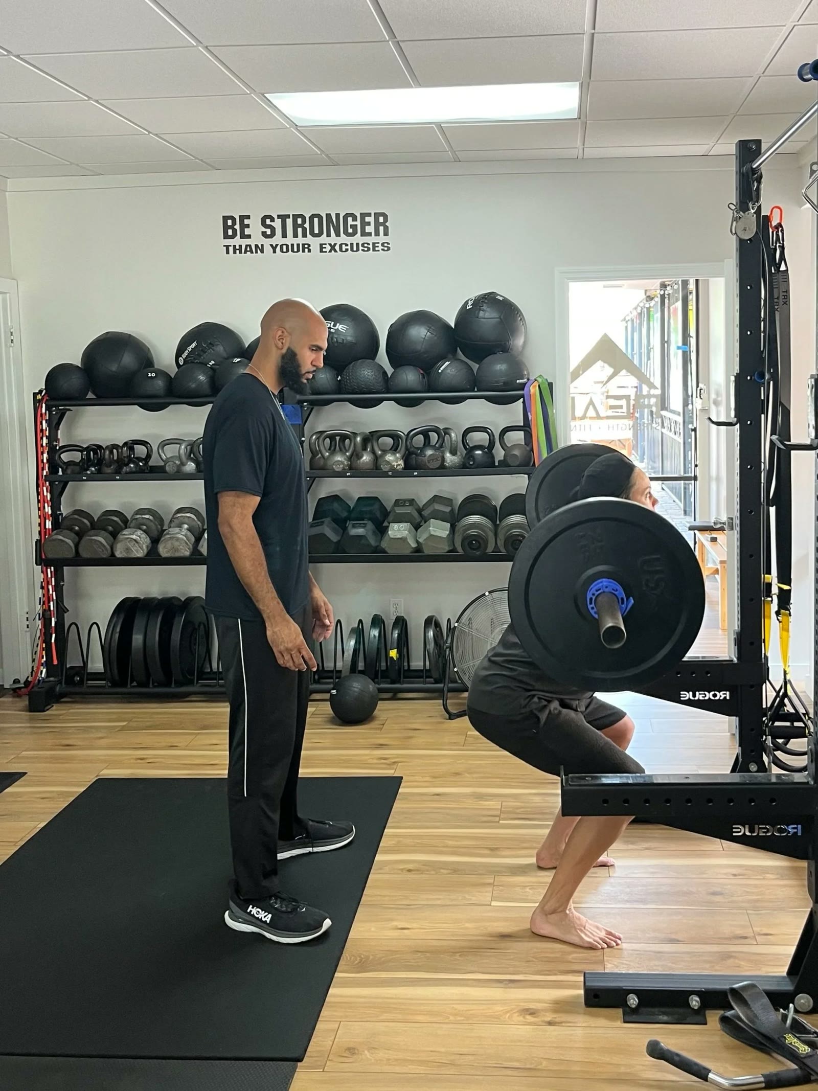A Peak coach working one-to-one with a member on squat technique