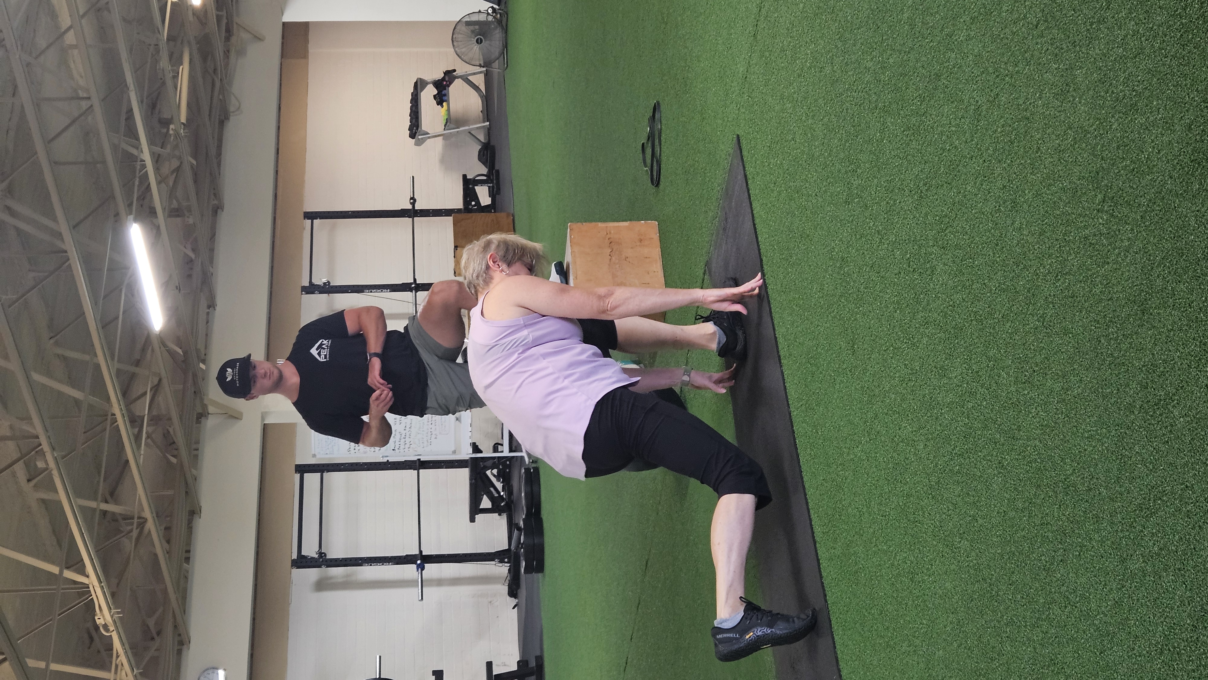 A Peak coach spotting a member on dumbbell press