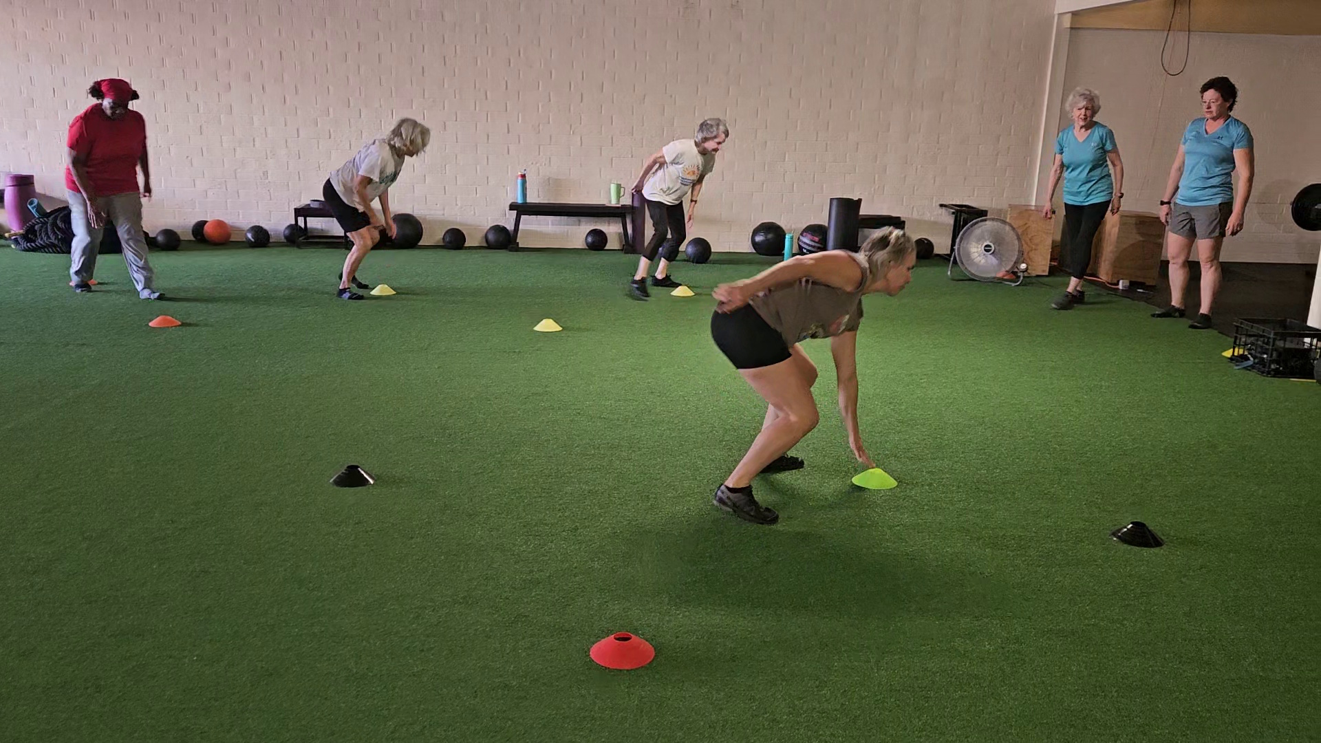A coach working with an older member in the rack